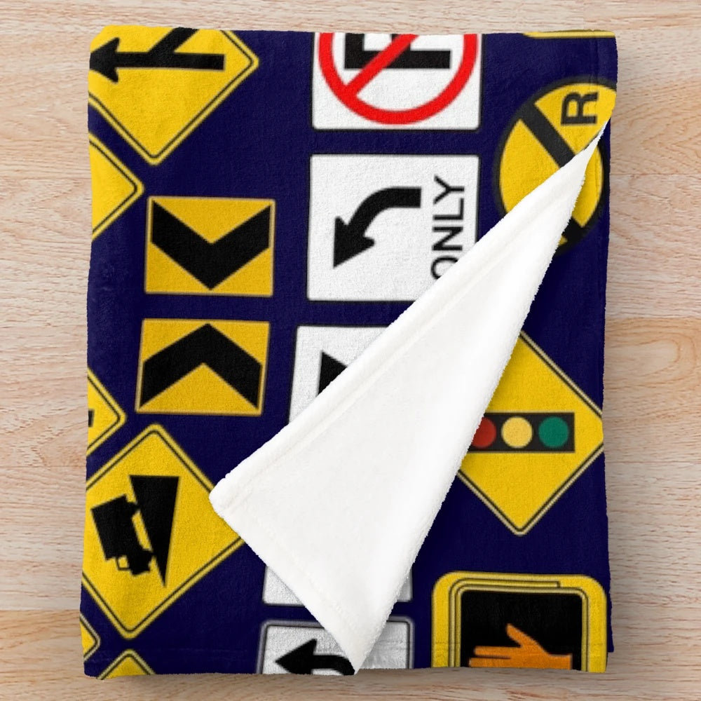 Road signs and traffic regulation symbols printed on a soft, plush blanket