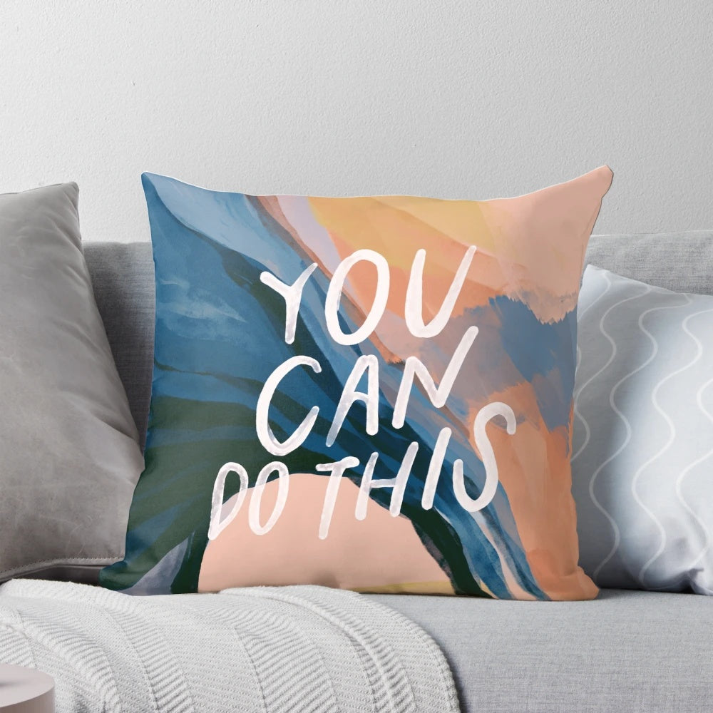 A plush, decorative pillow featuring an abstract art design and an inspiring, motivational quote.