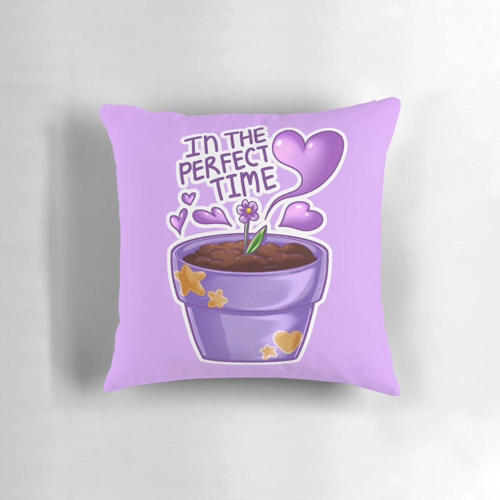 A violet-colored pillow with the text "Affirmations: In the Perfect Time" in a typography design, accompanied by heart and star icons.