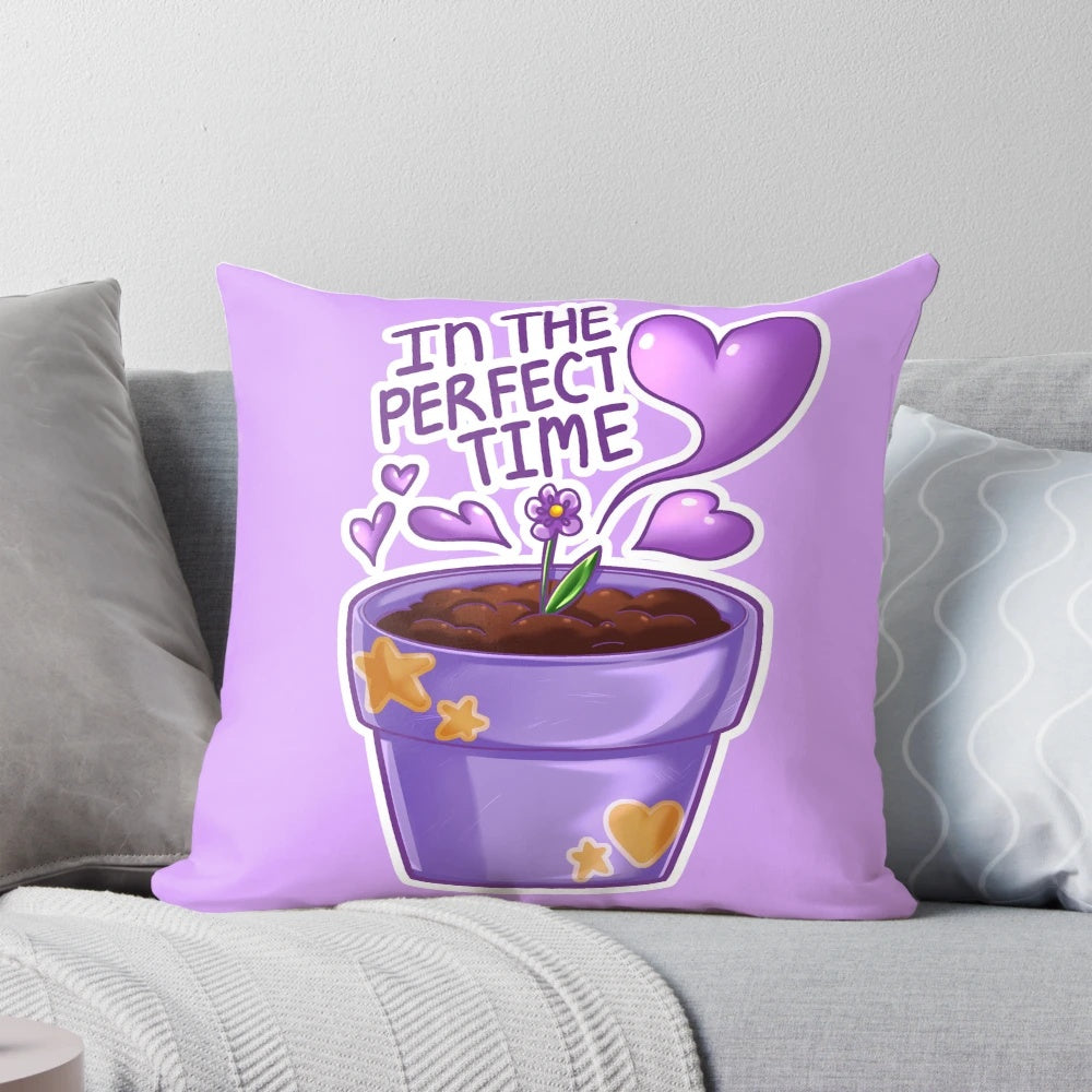 A violet-colored pillow with the text "Affirmations: In the Perfect Time" in a typography design, accompanied by heart and star icons.