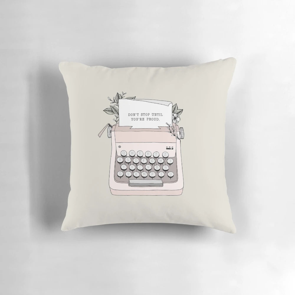 A white throw pillow with black text that says "Don't Stop" in a vintage typewriter font, surrounded by floral patterns.