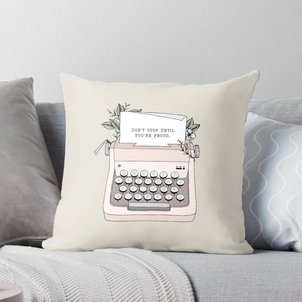 A white throw pillow with black text that says "Don't Stop" in a vintage typewriter font, surrounded by floral patterns.