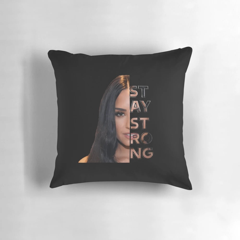 A soft, white pillow with the words "Stay Strong" and Demi Lovato's name printed on it.