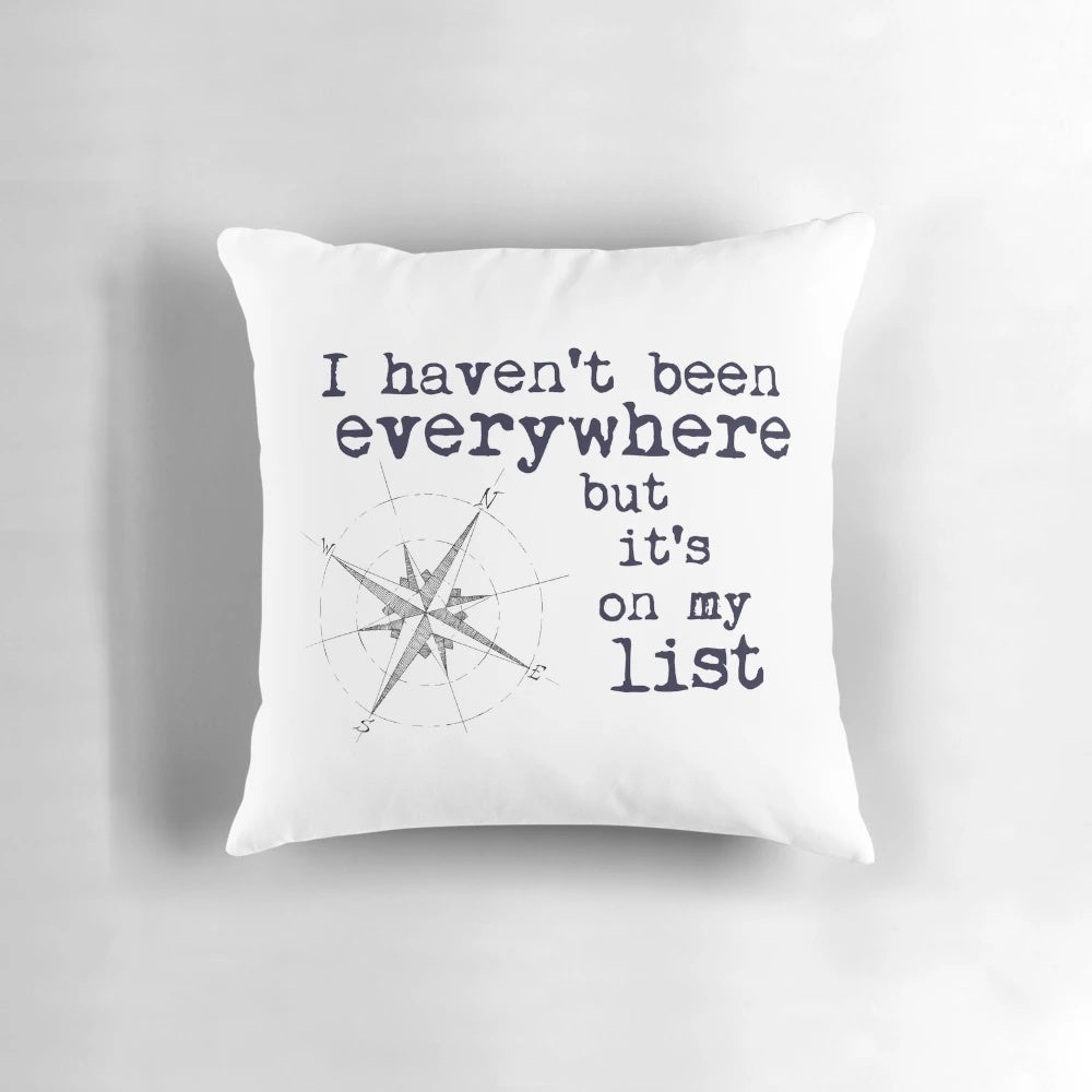 Throw pillow featuring the inspirational travel quote "I Haven't Been Everywhere But It's On My List" by Susan Sontag, with a globe and compass design.