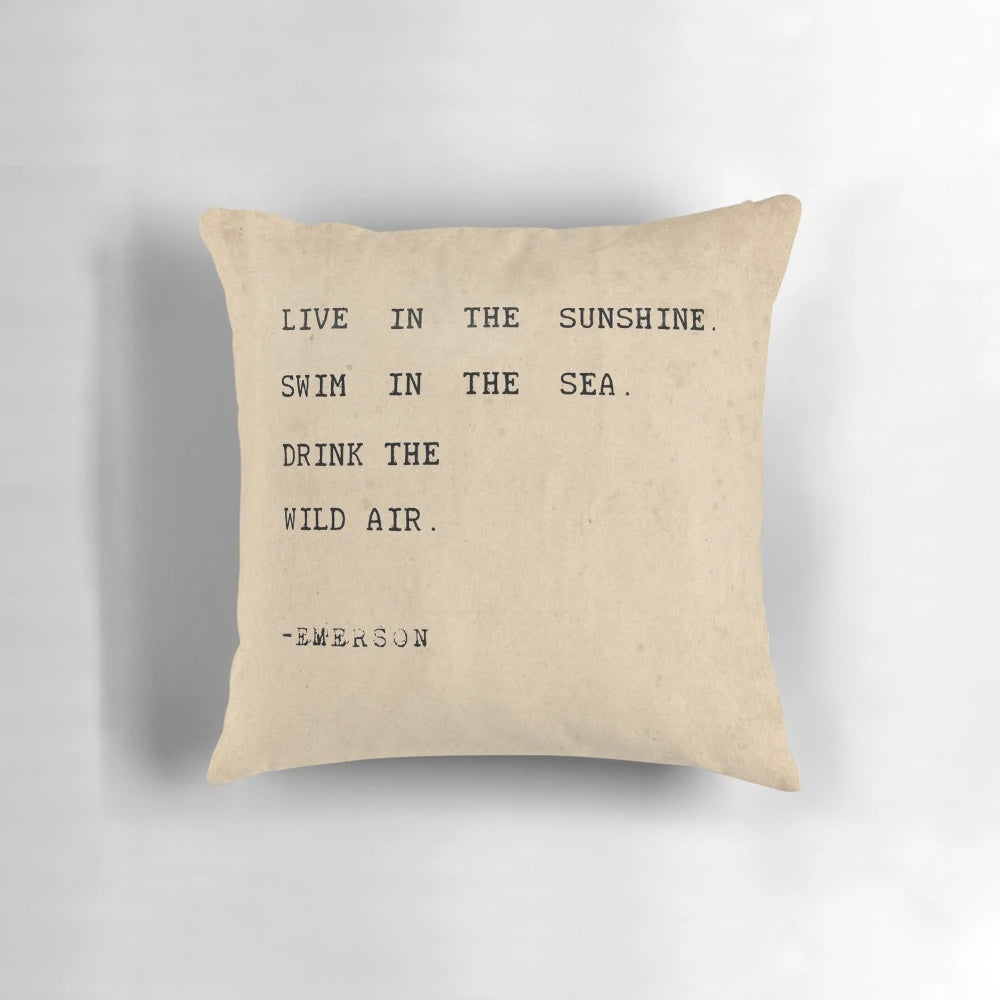 Pillow with inspirational typography quote "Live in the sunshine, swim in the sea, drink the wild air" in minimalist design