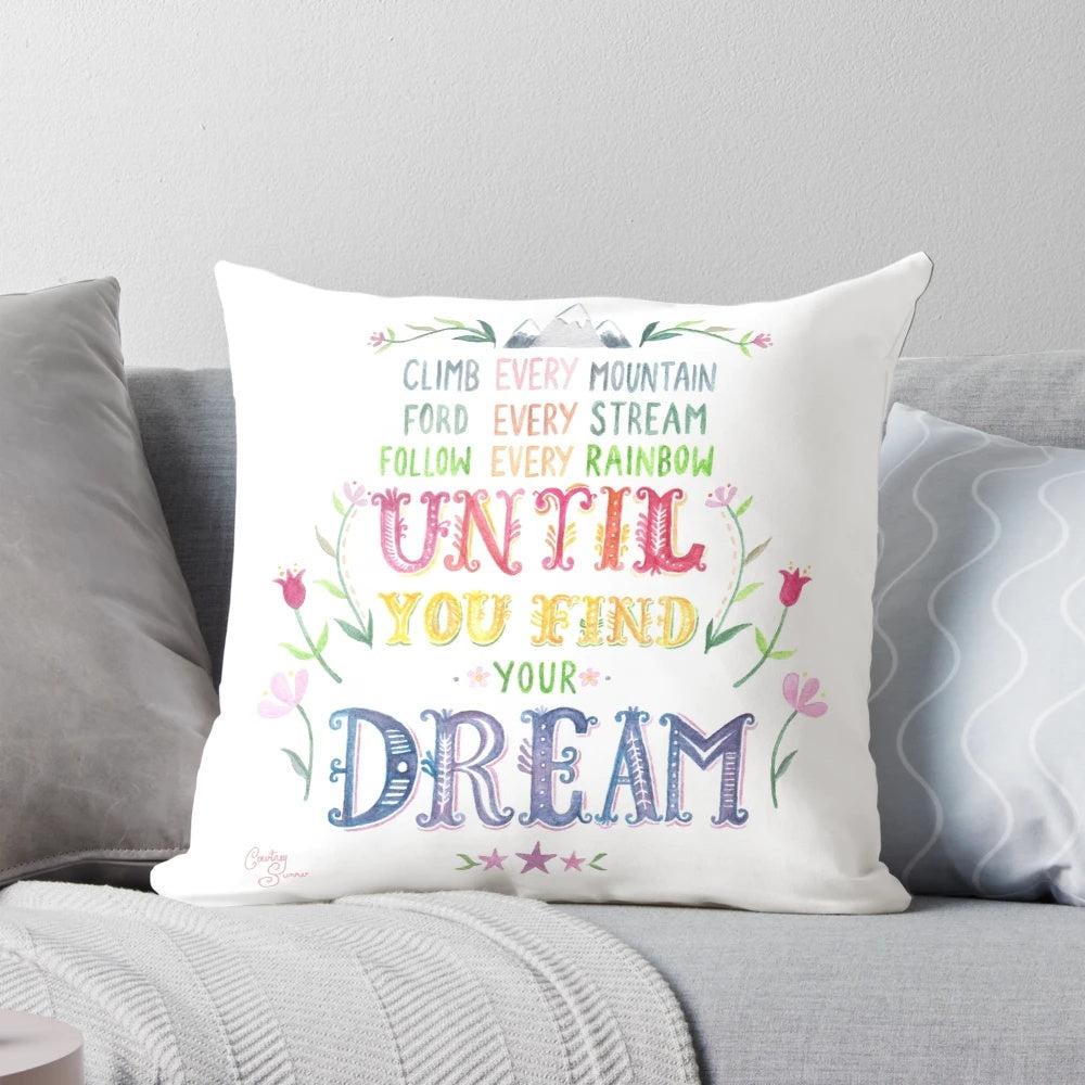 Colorful watercolor-style illustration of mountains and flowers with the words "Climb Every Mountain" on a soft, plush throw pillow.