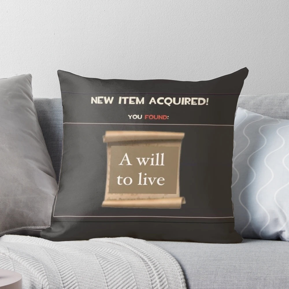 Close-up of a white pillow with the text "Will to Live" printed on it, a design that combines gaming, memes, and inspirational messages.