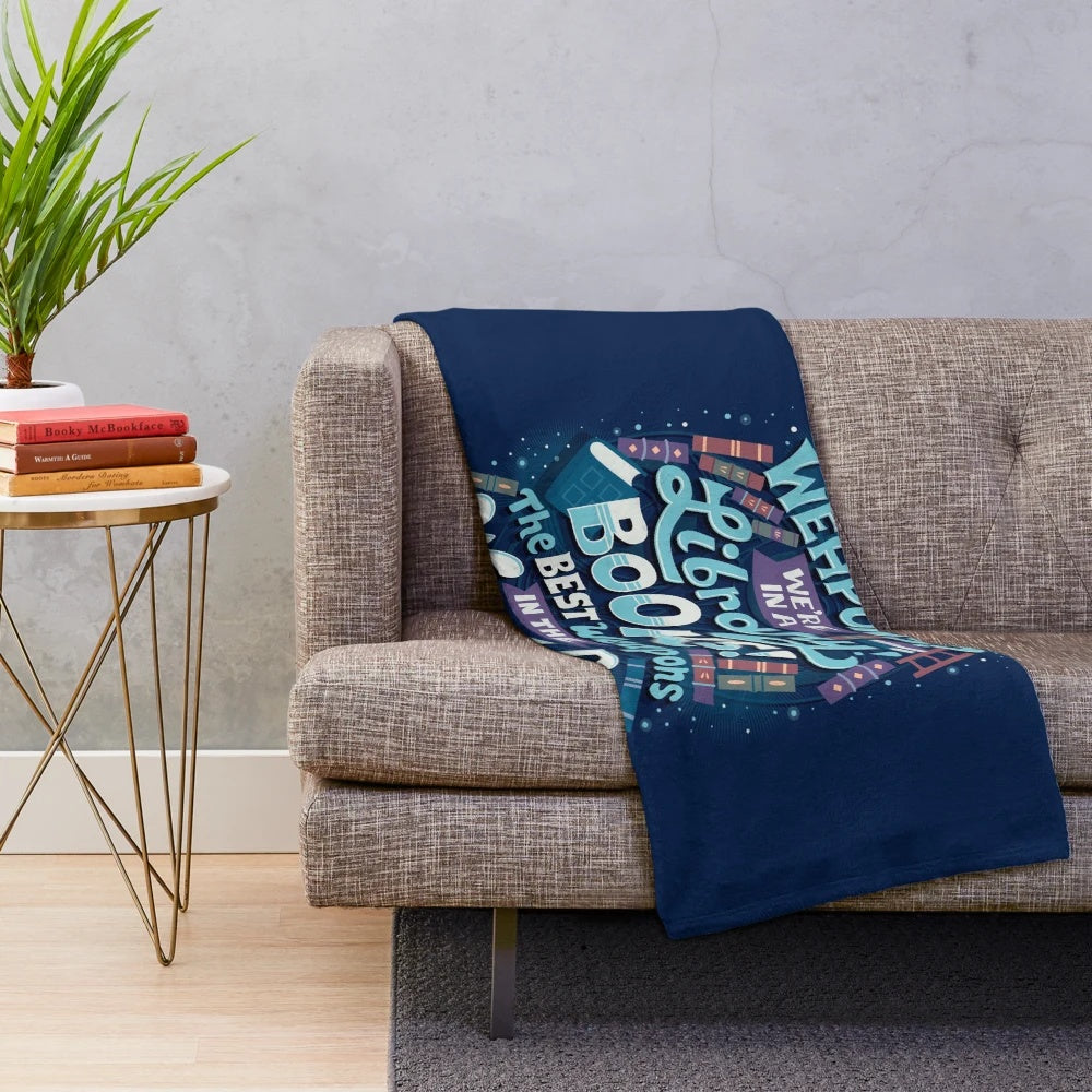 Plush blanket with the phrase "Books are the best weapons" in a stylized, hand-lettered design