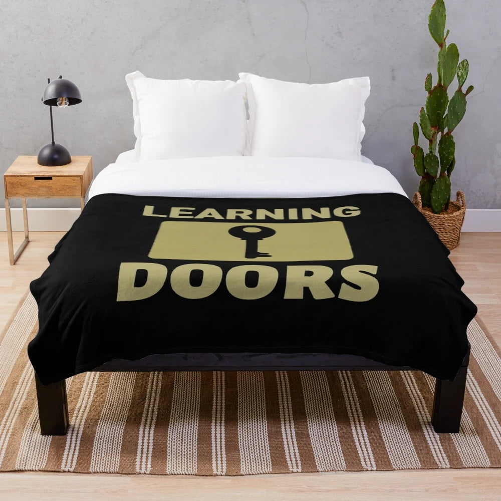 Plush blanket with inspirational "Learning Opens Doors" design, featuring teachers