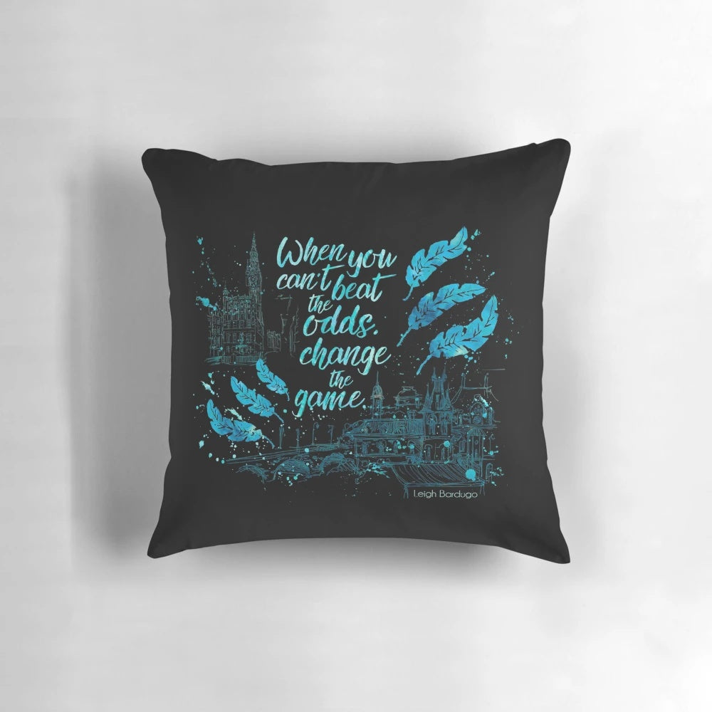 A decorative pillow featuring a quote from the book "Six of Crows" by Leigh Bardugo, with watercolor typography art.