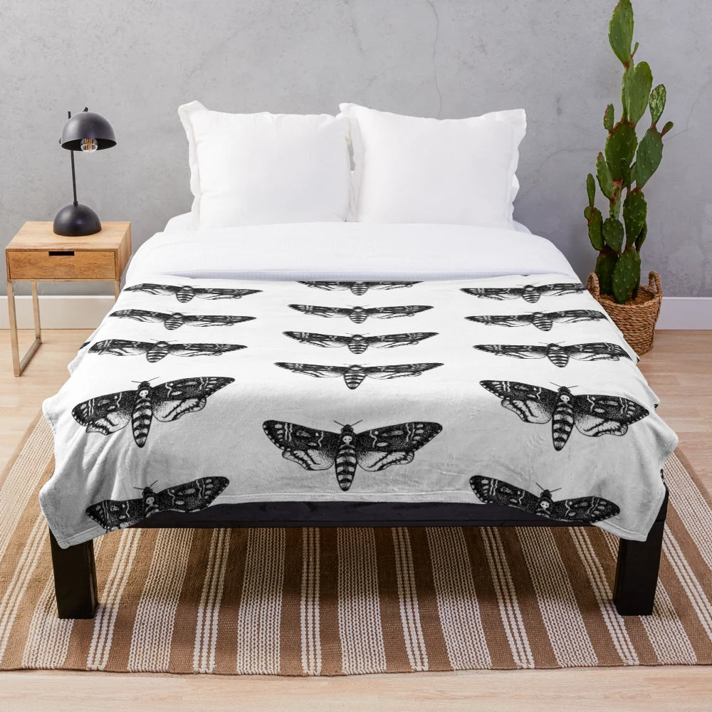 Detailed death's-head hawkmoth design on a plush, cozy blanket