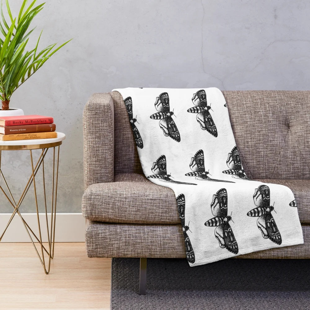 Detailed death's-head hawkmoth design on a plush, cozy blanket