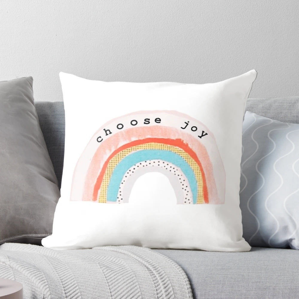 A colorful, decorative pillow featuring a "Choose Joy" design with rainbow colors and polka dots.