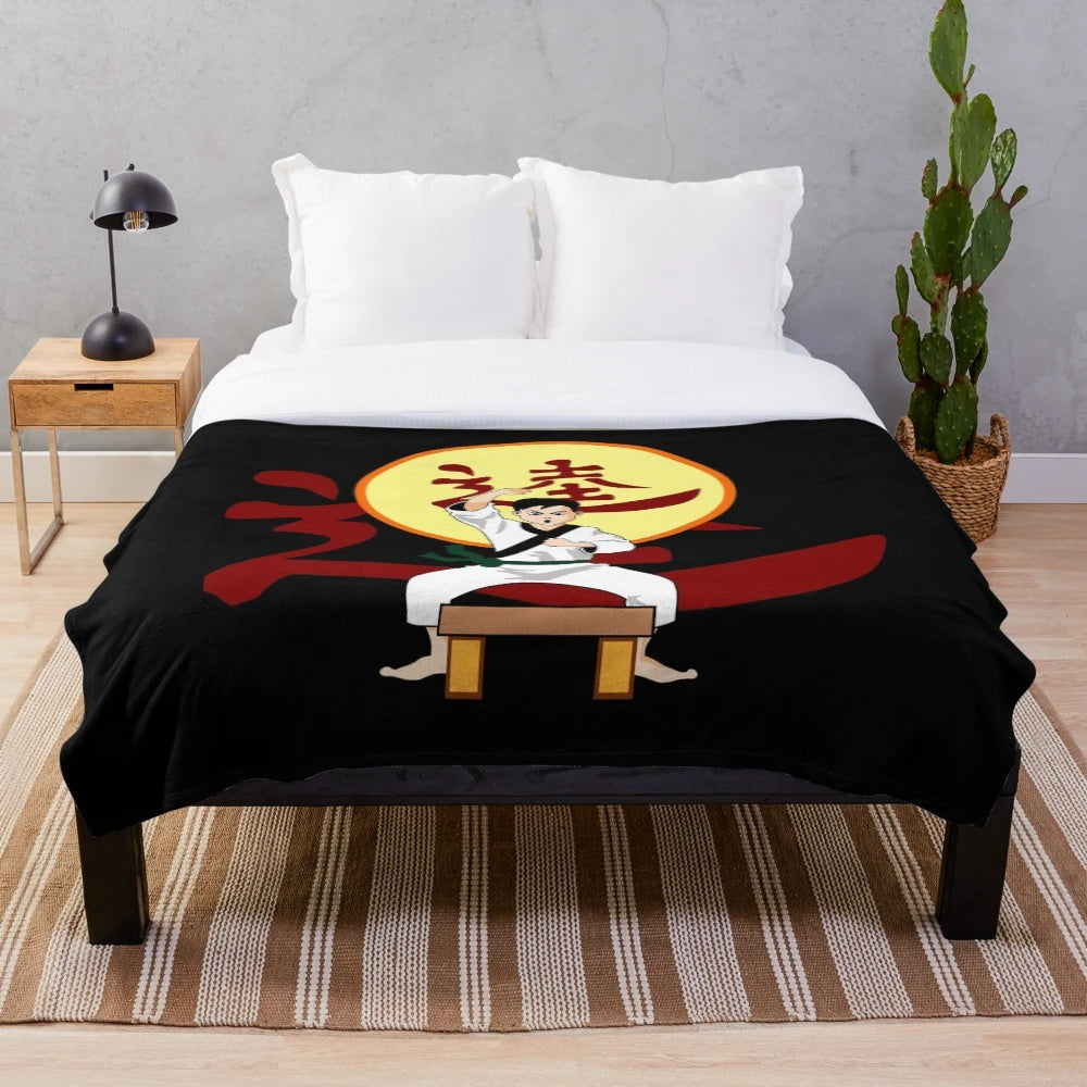 Karate-inspired plush blanket with karateka, chop, and colored belt imagery