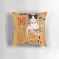 A decorative cat pillow featuring an impressionistic style portrait of a tuxedo cat in gold and earthy tones, inspired by the artwork of Gustav Klimt.