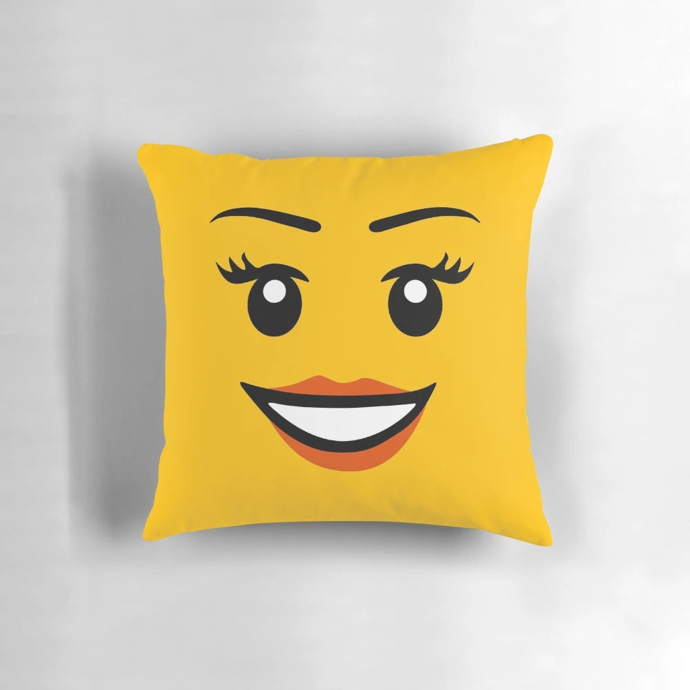 Colorful Lego-style girl face pillow in yellow with a happy, smiling expression.