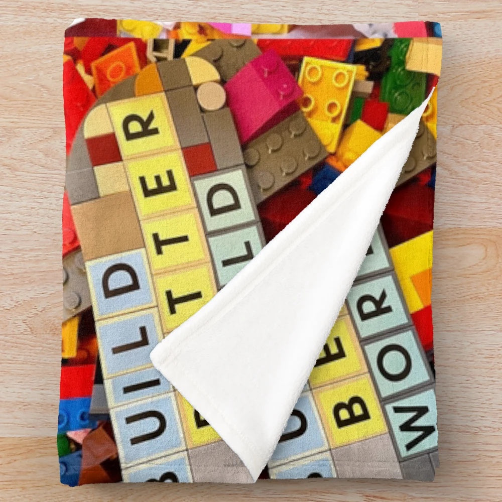 Lego-inspired plush blanket depicting the message "Build a Better World