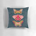 Close-up photograph of a pillow featuring a design of colorful moths and butterflies in a natural, botanical setting.