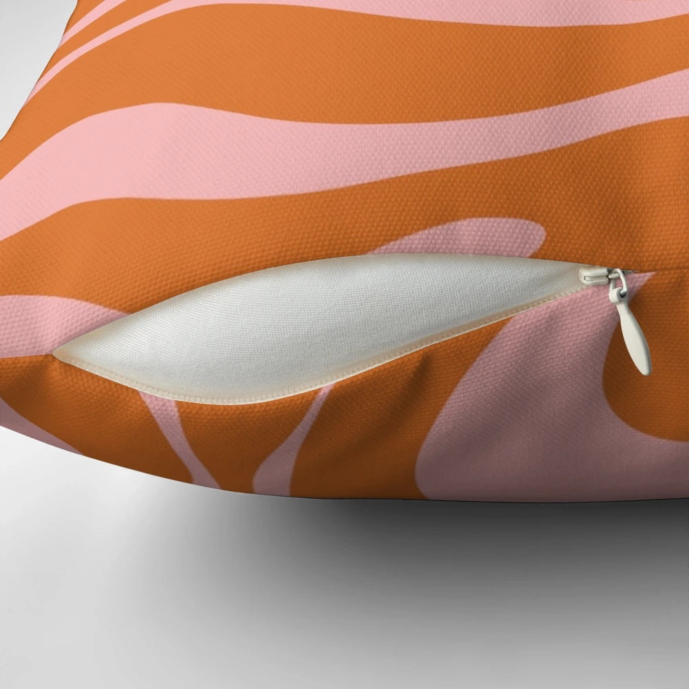 Colorful abstract pattern pillow with a retro liquid swirl design in orange and pink.