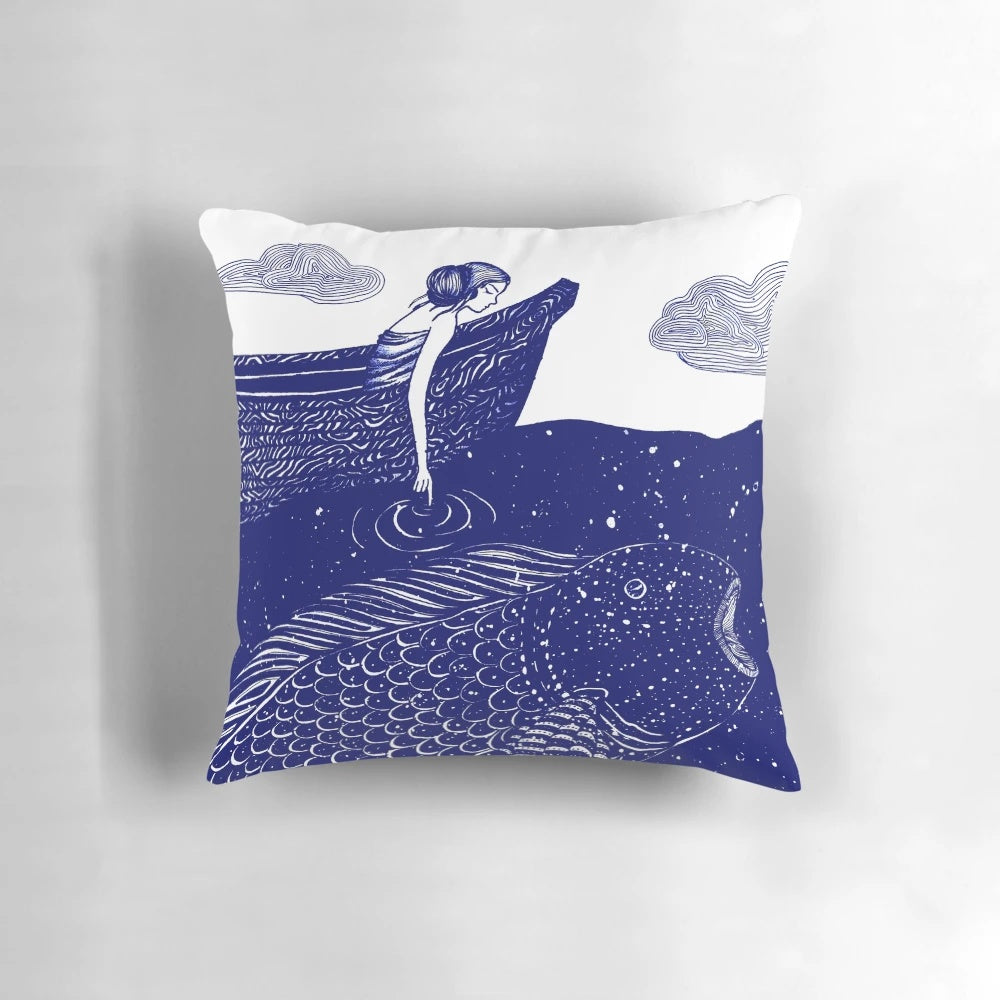 A decorative throw pillow featuring a serene, shimmering ocean scene with a blue background and whimsical elements like goldfish and a girl in a boat.