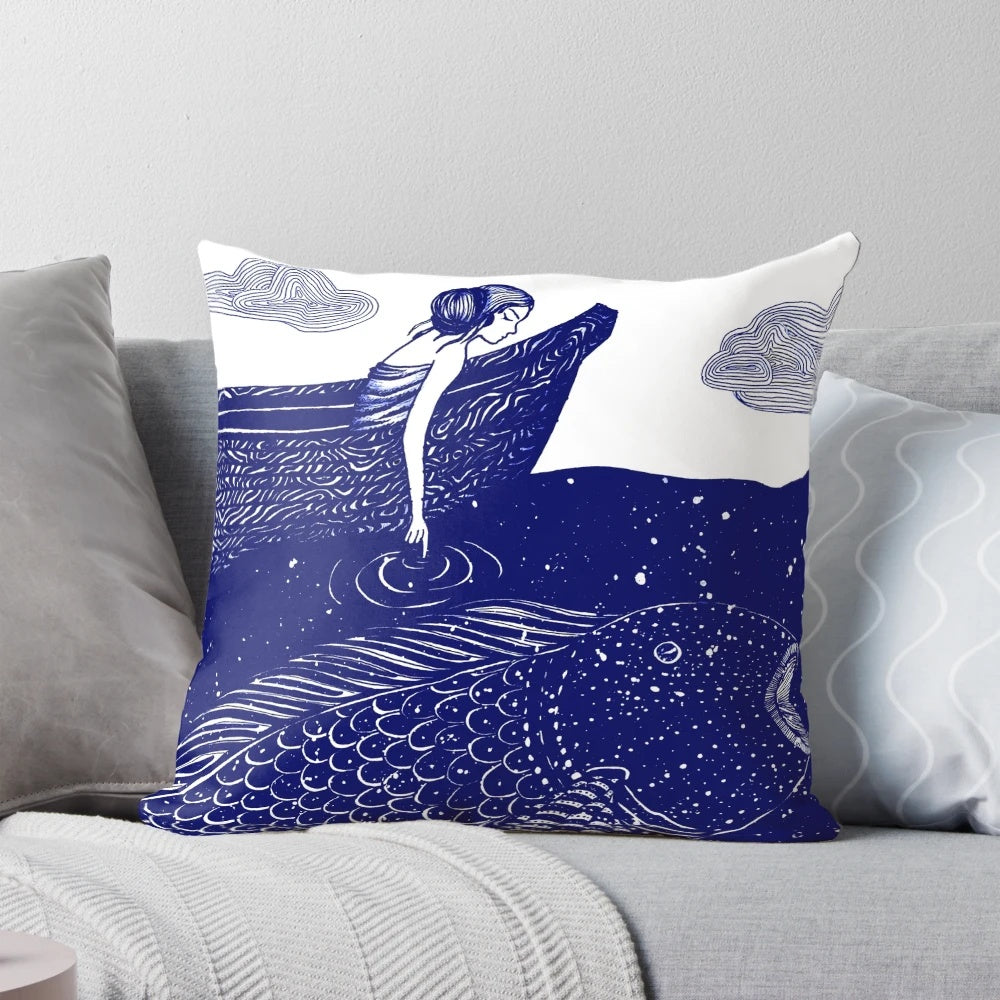 A decorative throw pillow featuring a serene, shimmering ocean scene with a blue background and whimsical elements like goldfish and a girl in a boat.