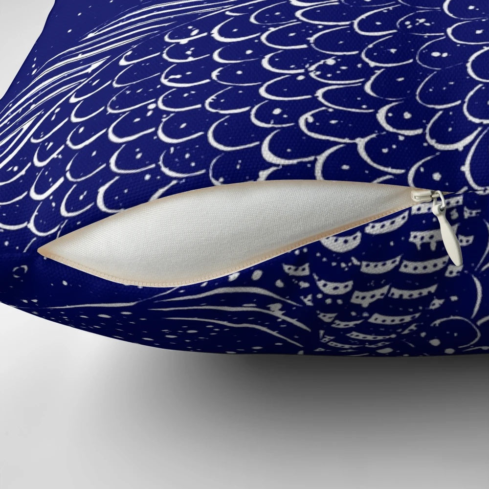 A decorative throw pillow featuring a serene, shimmering ocean scene with a blue background and whimsical elements like goldfish and a girl in a boat.