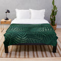 Dark green plush blanket with foliage pattern