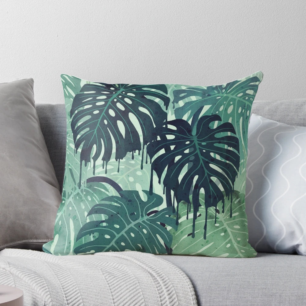 Green monstera leaf printed on a decorative pillow with surreal, tropical vibes