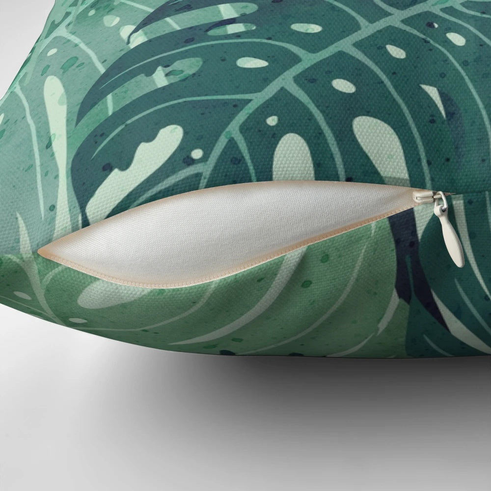 Green monstera leaf printed on a decorative pillow with surreal, tropical vibes