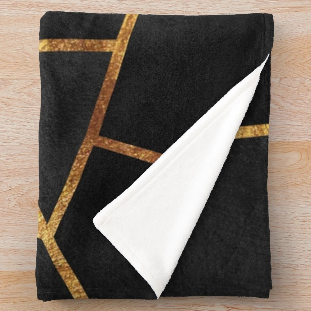 Black and gold geometric plush blanket with abstract marble pattern
