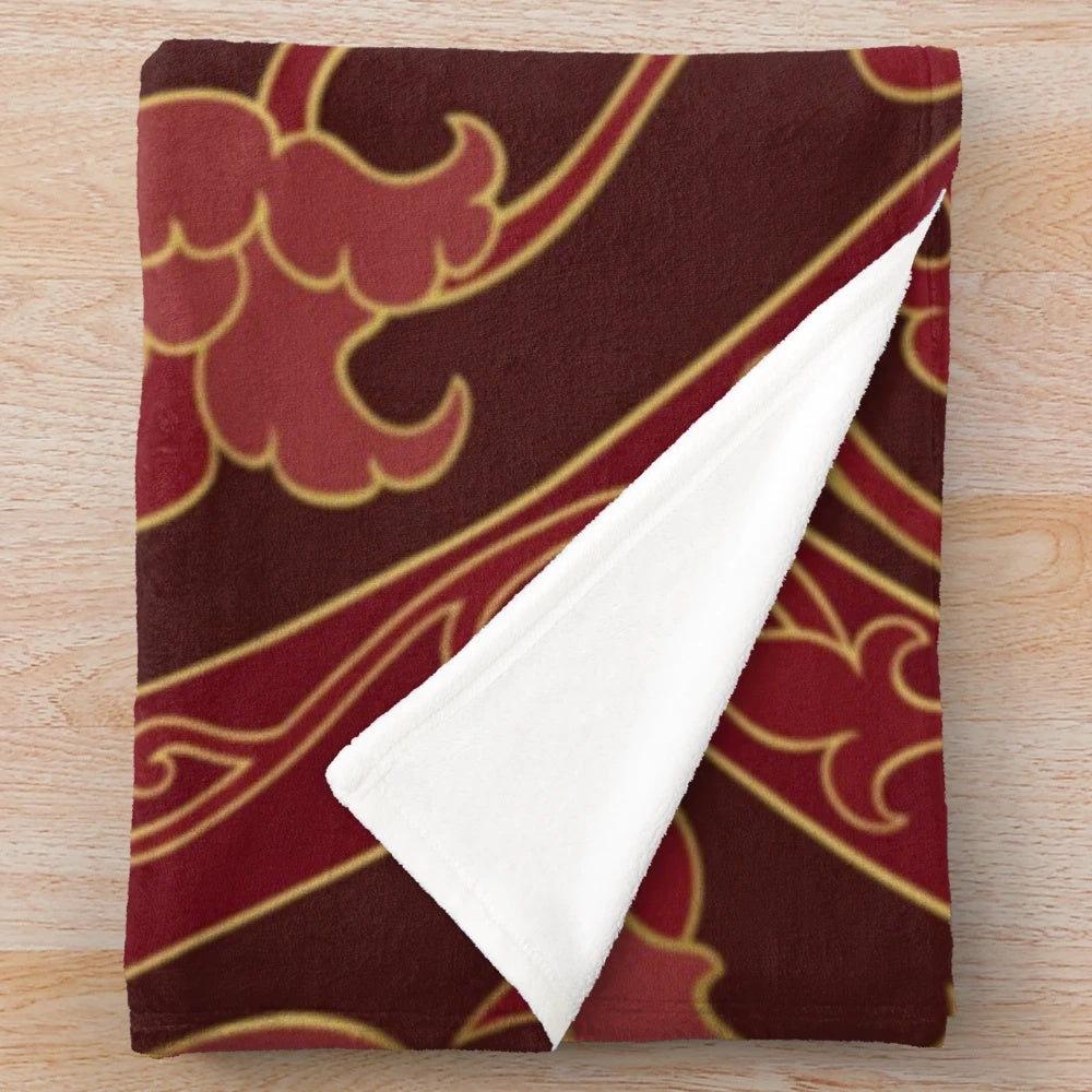 Burgundy plush blanket folded on a couch