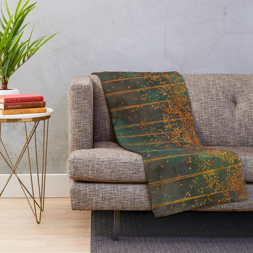 Closeup of a metallic copper plush blanket with botanical birch tree print
