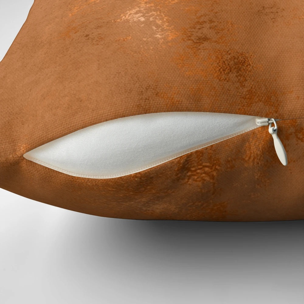 Closeup of a black and white geometric pattern pillow with metallic copper accents