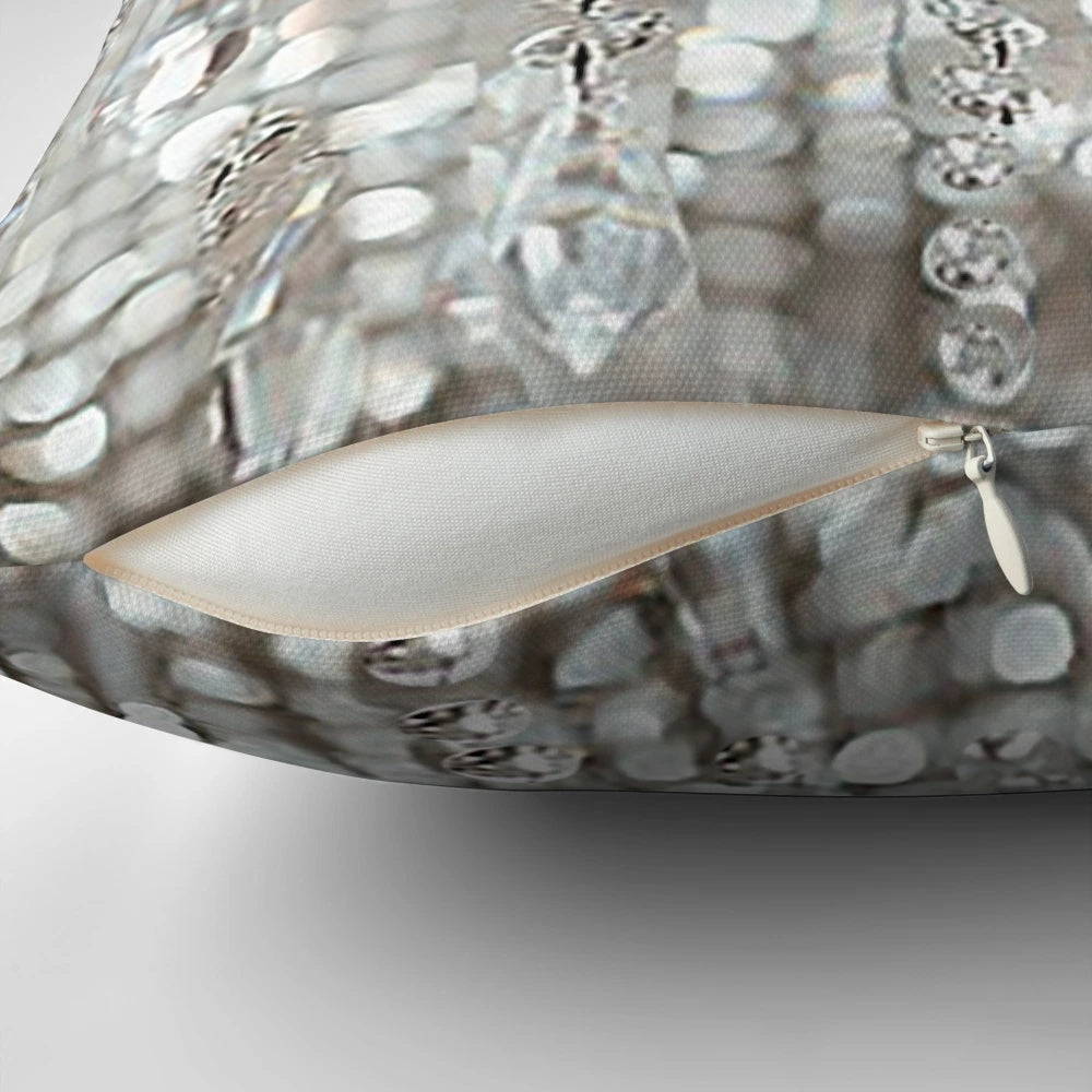 A decorative pillow featuring a photographic image of a crystal chandelier with brilliant lights.