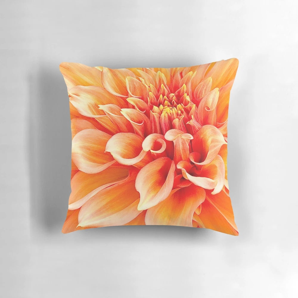 Vibrant orange dahlia flower pillow with ruffled and swirling design