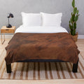 Dark plush blanket with a leather-like patterned design