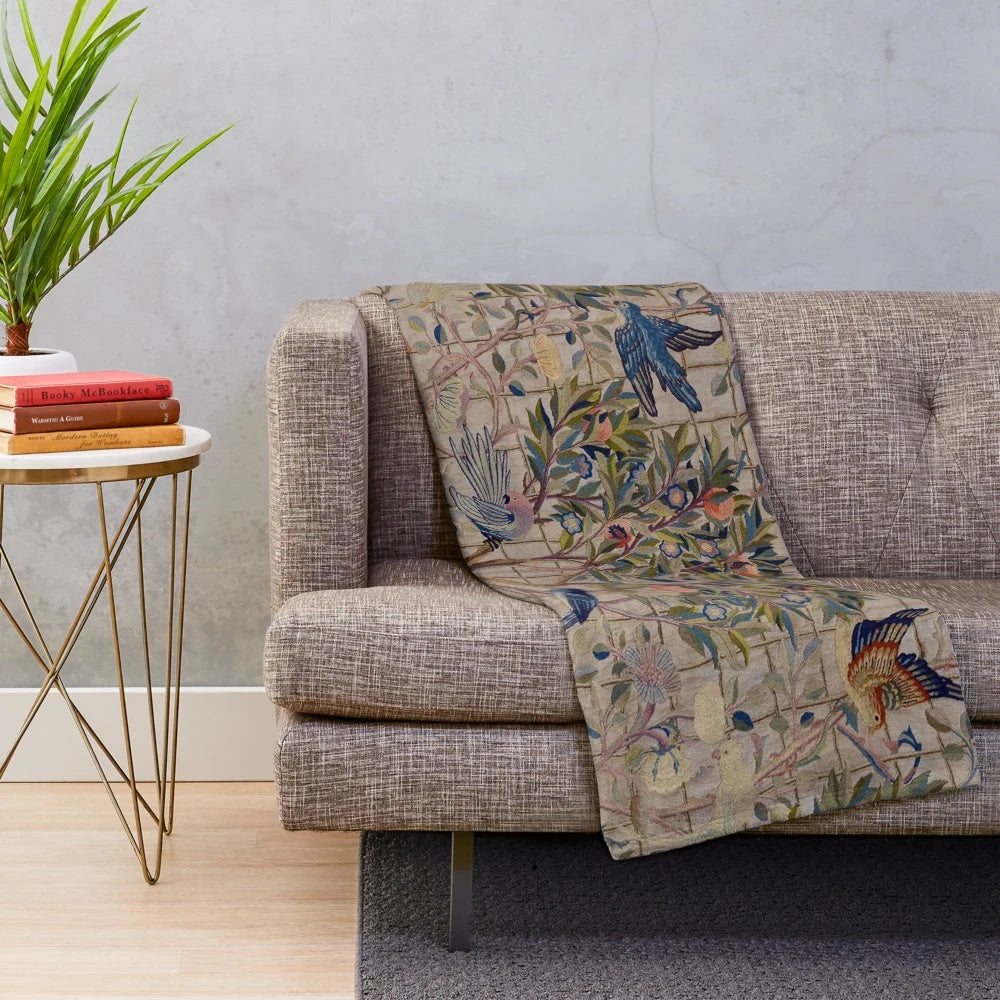 Closeup of a soft, plush blanket featuring a vintage-inspired floral trellis pattern in shades of green, red, and white.