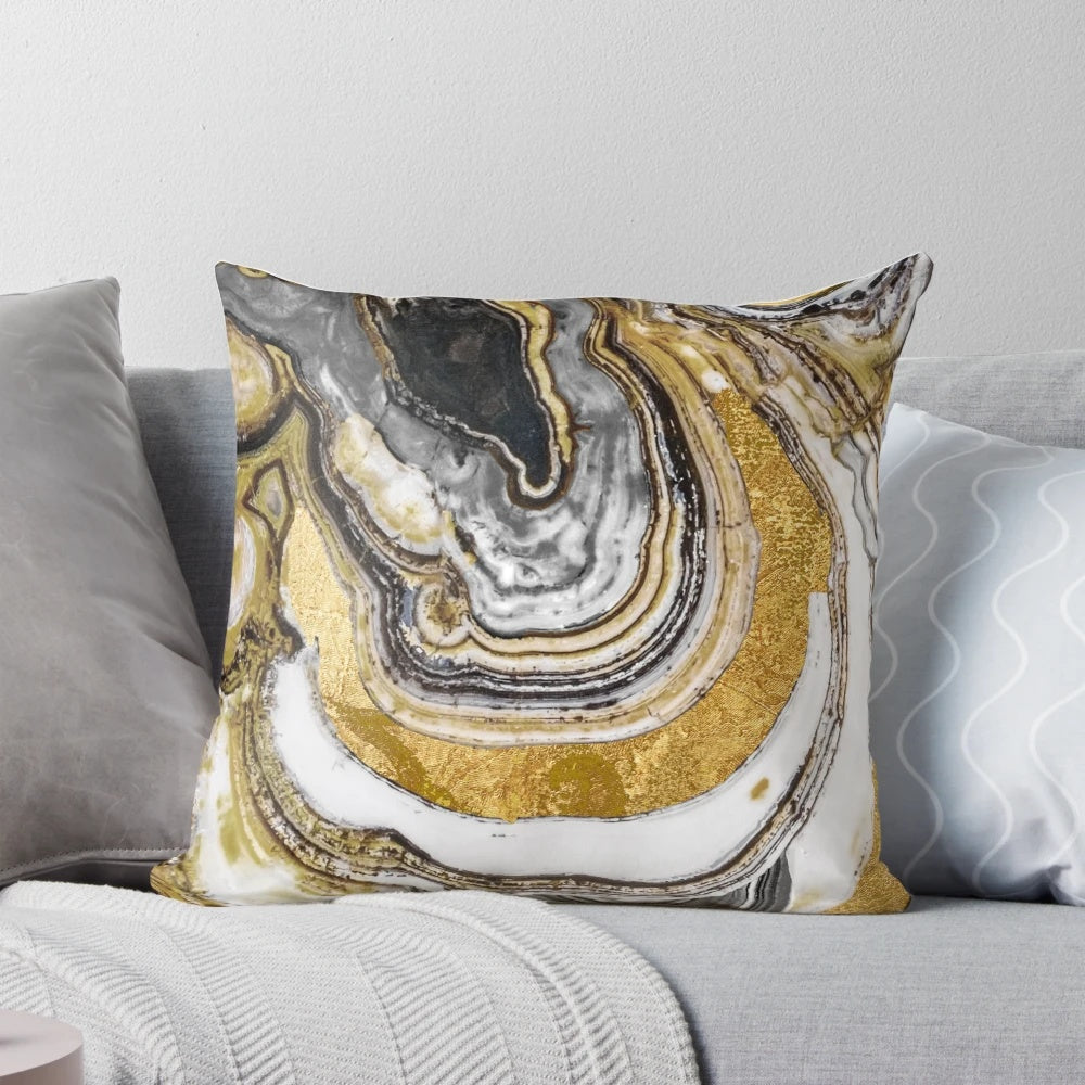 Close-up of a gold and black natural geode stone on a decorative pillow