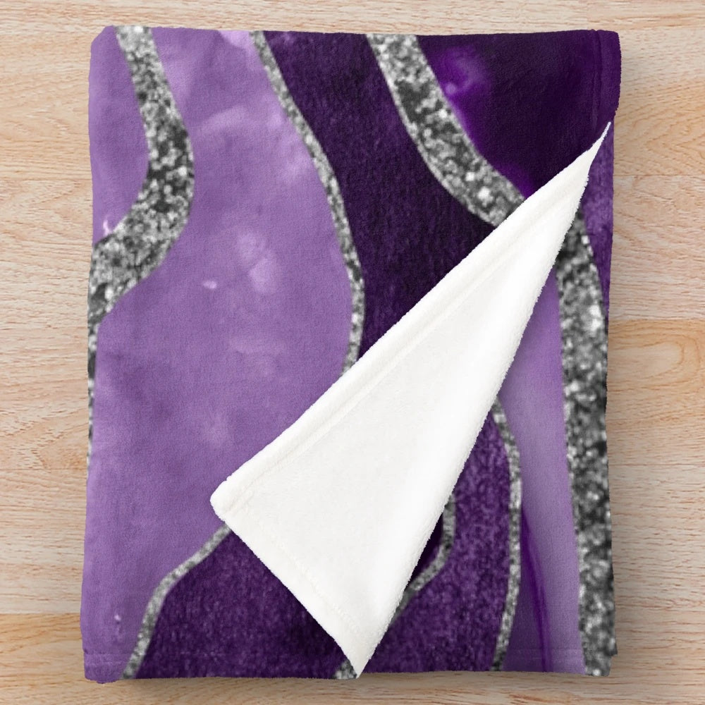Plush blanket with abstract marble and agate design in shades of purple and silver glitter