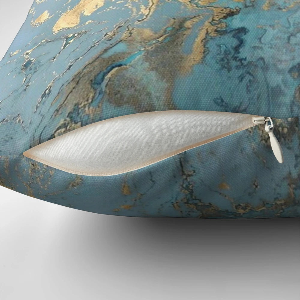 Marble-inspired decorative pillow with teal, gold, and geometric patterns