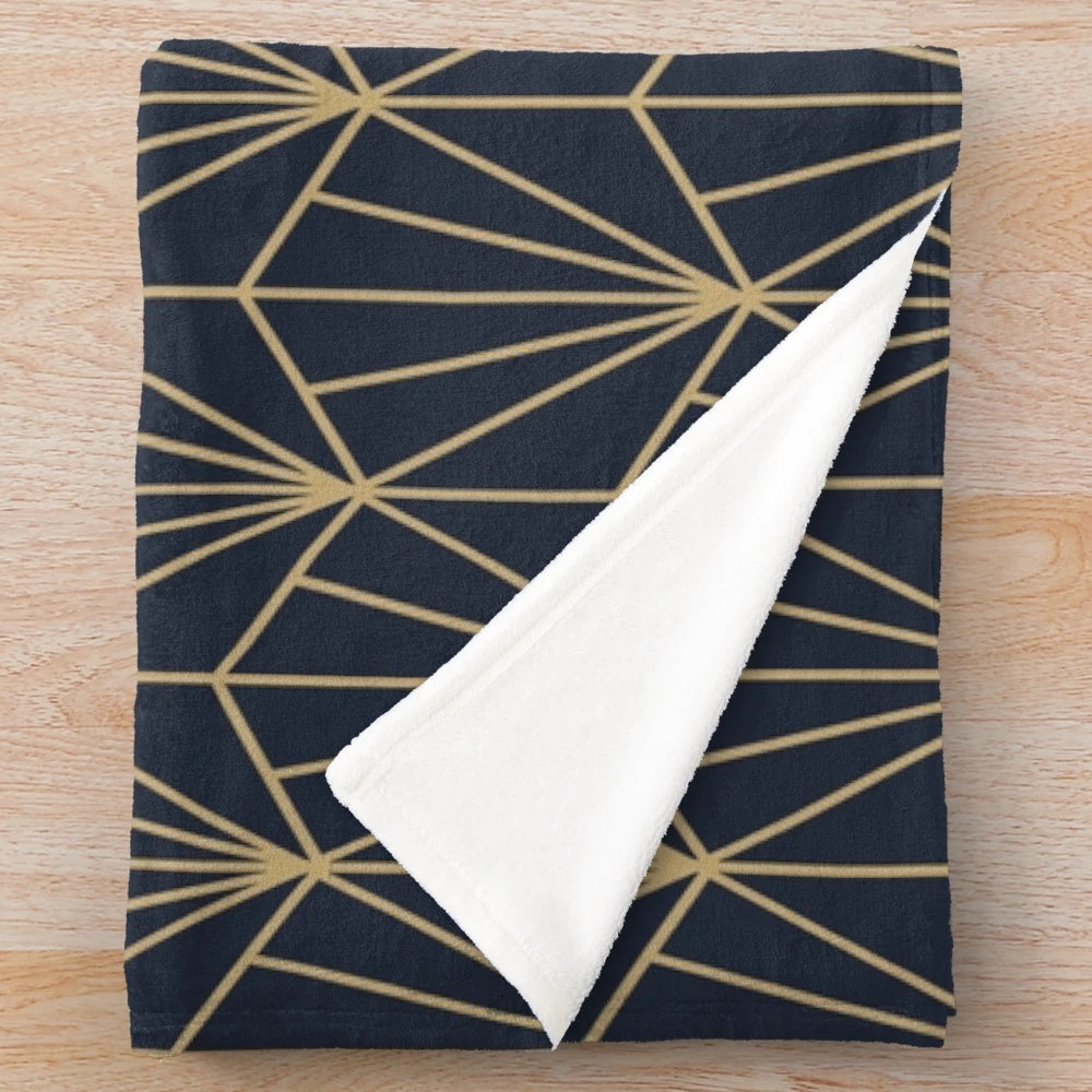 Navy and gold plush blanket with an art deco style geometric pattern