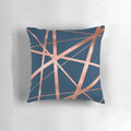 Closeup of a navy blue and rose gold geometric pattern pillow