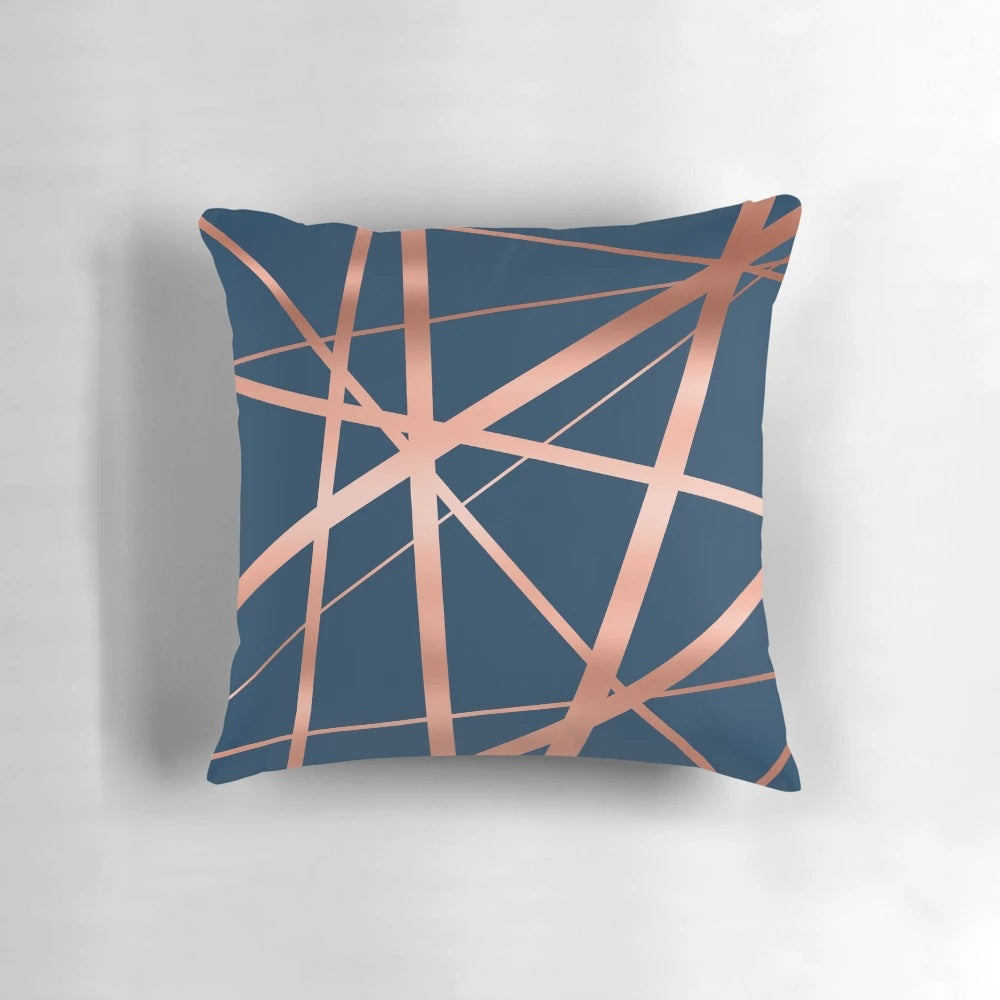 Closeup of a navy blue and rose gold geometric pattern pillow