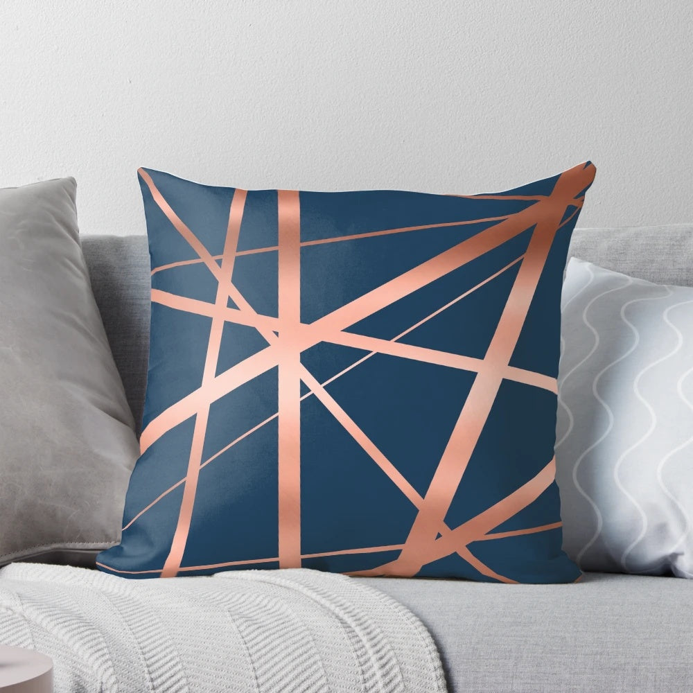 Closeup of a navy blue and rose gold geometric pattern pillow