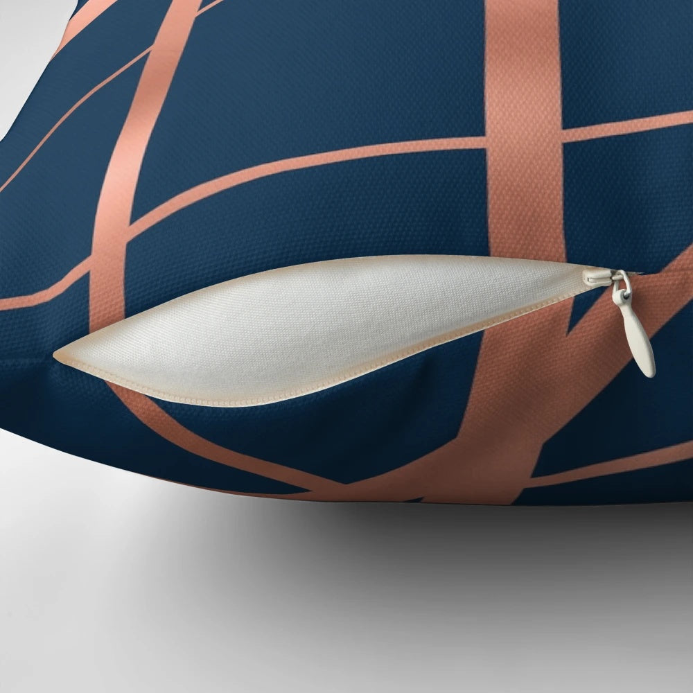 Closeup of a navy blue and rose gold geometric pattern pillow