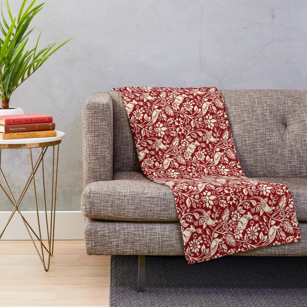 Plush blanket with a vintage-inspired pheasant and hare pattern in deep red and cream colors