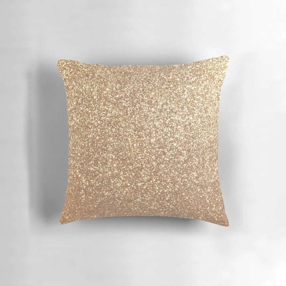 Close-up of a soft, shimmering rose gold metallic pillow with a glittery finish.