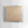 Close-up of a soft, shimmering rose gold metallic pillow with a glittery finish.
