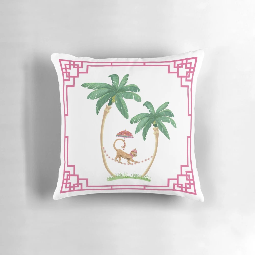 A decorative pillow featuring two palm trees and a cute royal monkey in a chinoiserie-inspired design.