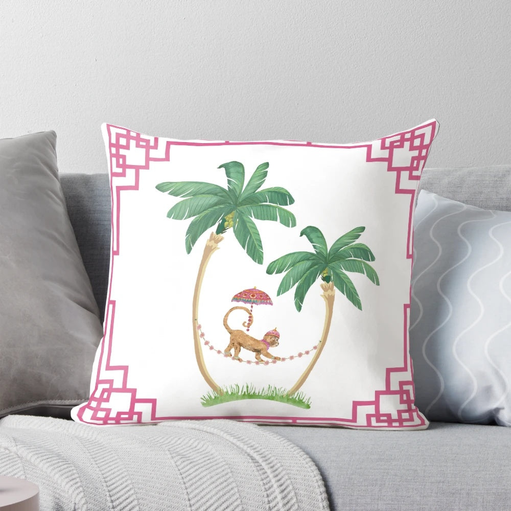 A decorative pillow featuring two palm trees and a cute royal monkey in a chinoiserie-inspired design.